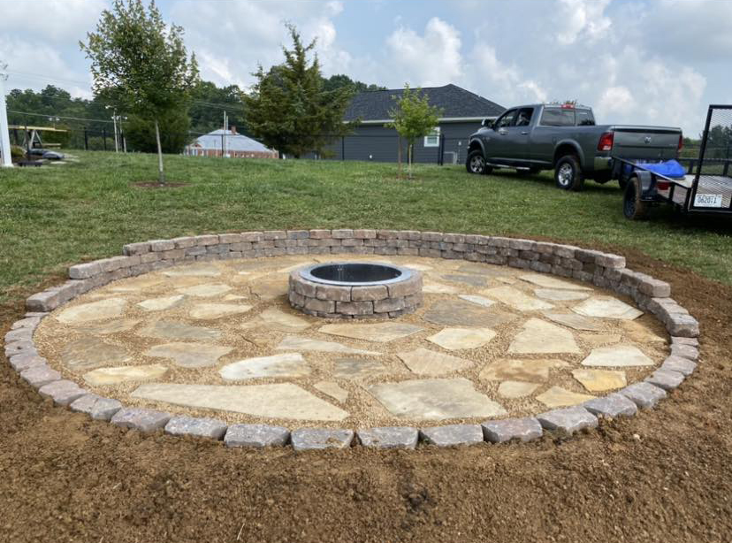 Circular stacked-stone fire pit patio installation in progress