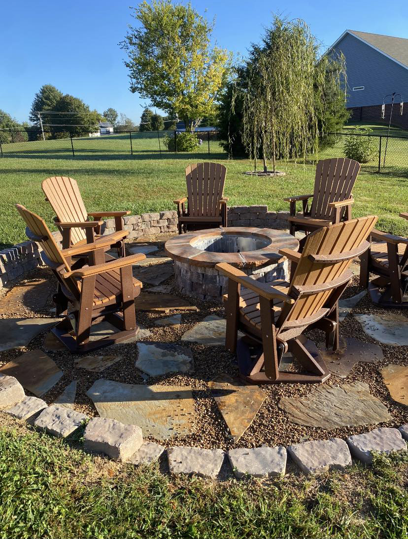 Fire pit surrounded by Adirondack chairs on a flagstone patio